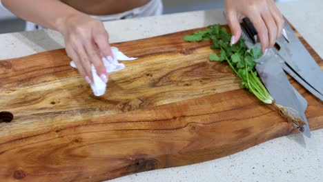 woman cleaning a wooden chopping board