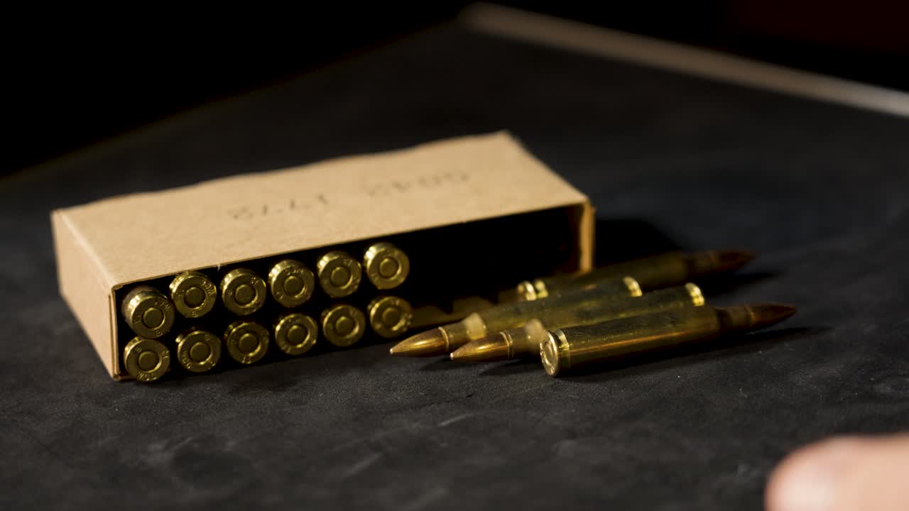 Several unfired rounds of 5.56 rolling into frame.