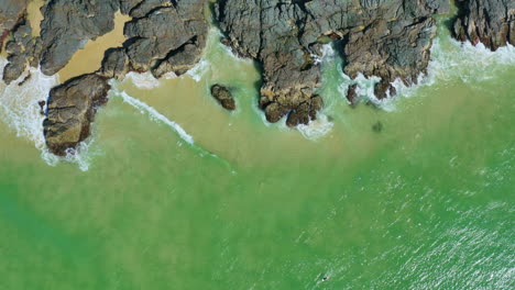 4k aerial drone birds eye view over rocky beach shore in australia