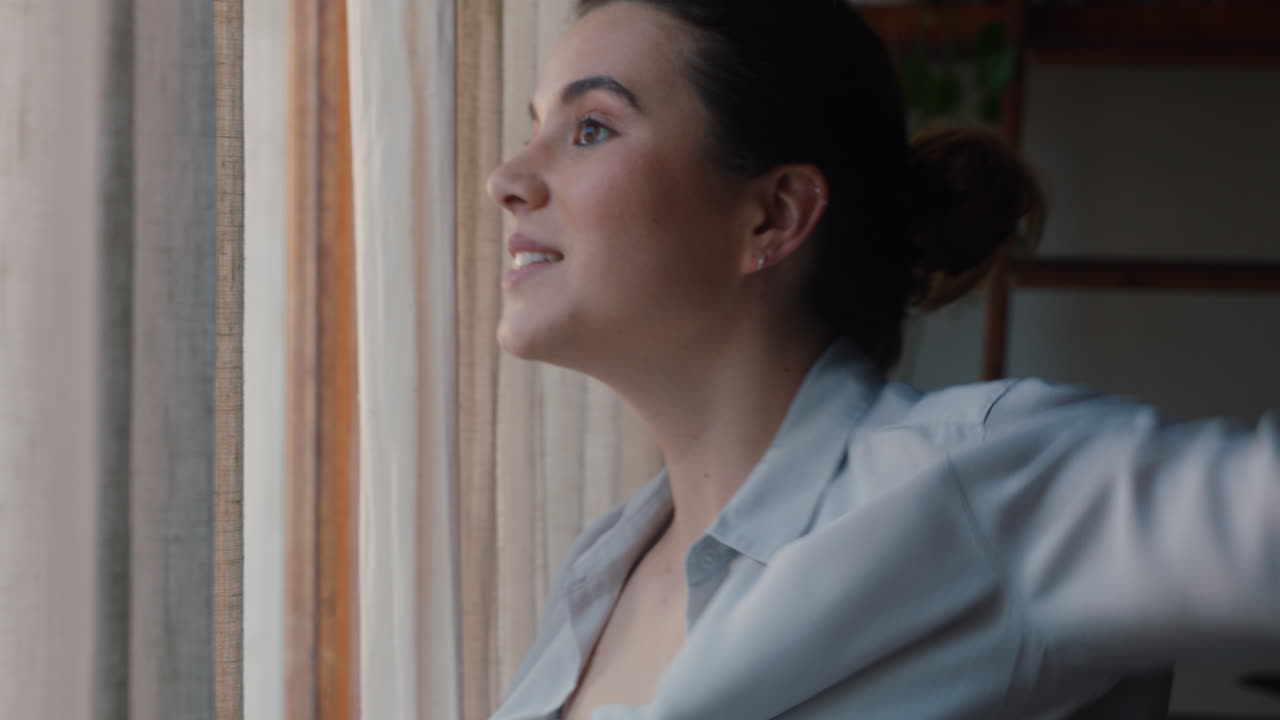 hermosa mujer joven vistiéndose preparándose tarde para el trabajo mirando por la ventana disfrutando del nuevo día sintiéndose descansada