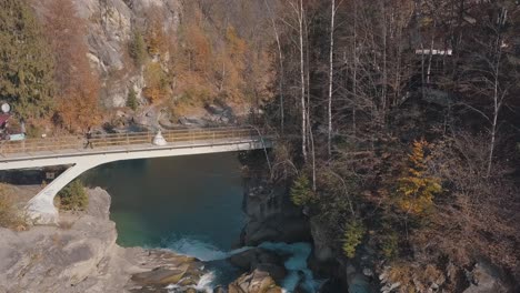 Frischvermählte.-Braut-Und-Bräutigam-Auf-Einer-Brücke-über-Einem-Gebirgsfluss.-Luftaufnahme