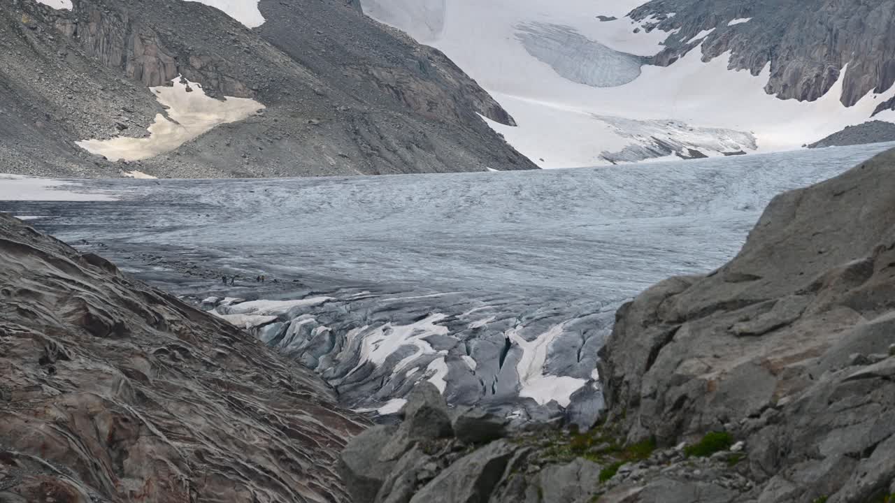 glaciar azul del ródano en la cima de los alpes con montañas rocosas y nevadas a un lado, suiza, valais