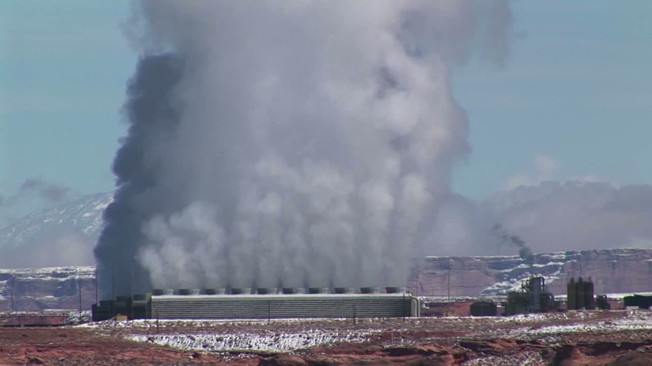 연기 구름을 방출하는 애리조나 사막에 있는 공장의 미디엄 샷