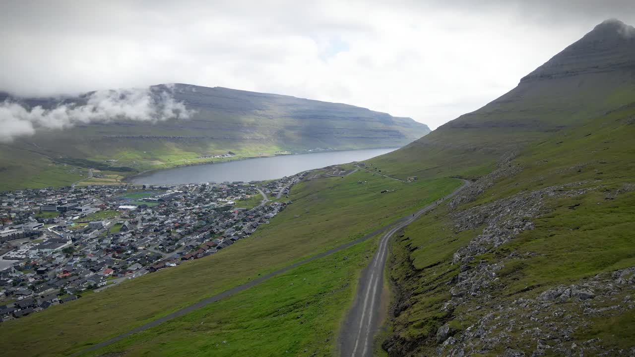 푸른 언덕과 조용한 피오르드 사이에 자리 잡은 클라크스비크의 숨을 는 공중 전망. 휘어지는 도로, 굴곡하는 경사, 그리고 아한 마을은 그림 같은 북유럽 풍경을 만니다.