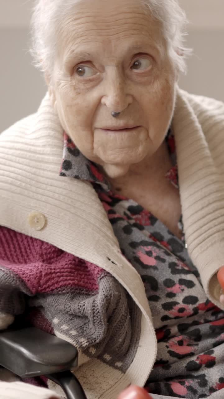 Old woman exercising with dumbbells sitting on a nursing home