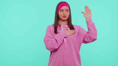 sincere responsible teen girl raising hand to take oath promising to be honest and to tell truth