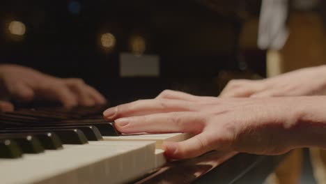 musician playing grand piano accompanied by violin