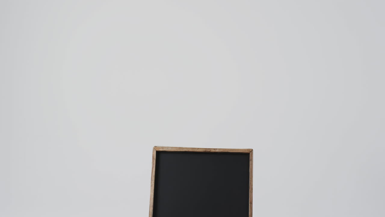 Video of blackboard sign on wooden stand with copy space on white background