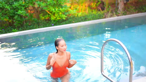 sexy slim asian woman in swimsuit going out from pool water fashion and tropical holiday concept, full frame slow motion