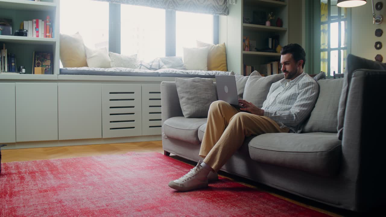 현대적인 거실의 소파에서 노트북으로 일하는 남자