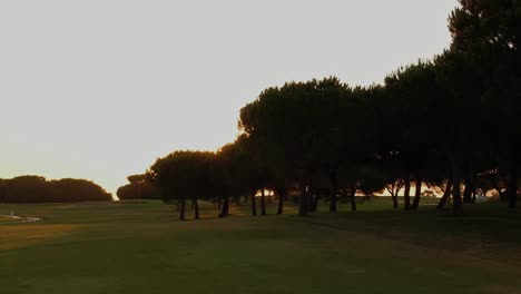 Golfplatz-Bei-Sonnenuntergang-Mit-Einem-Sonnigen-Sonnenuntergangshimmel