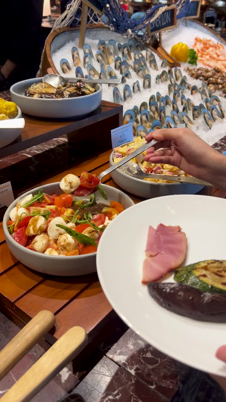 Una mano serve insalata caprese fresca su un piatto a una stazione di buffet di lusso a base di pesce
