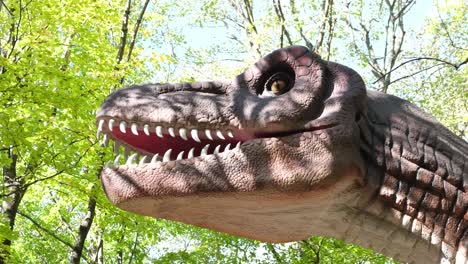 zoomin image of the head of a scary dinosaur with big teeth against a background of forest and sky zoomin image of the head of a scary dinosaur with big teeth against a background of forest and sky modern models of dinosaurs