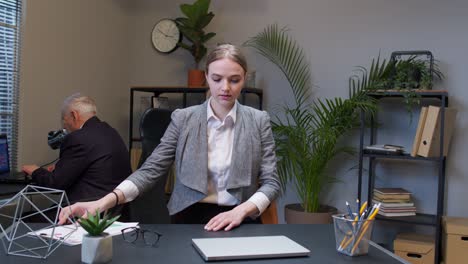 Businesswoman-freelancer-in-office-walking-and-sit-at-workplace-with-laptop-computer,-start-working