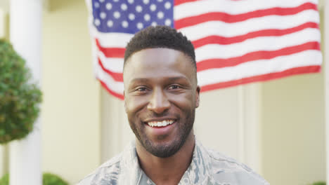 portrait of african american male soldier smiling over american flag