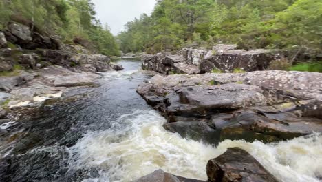 Toma-Panorámica-De-Una-Caída-De-Perros-Que-Fluye-Rápidamente,-Glen-Affric