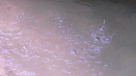 gotas de agua goteando sobre la superficie del agua piscina de agua dulce en un entorno natural al aire libre, fuente de agua potable fría y fresca durante la caminata