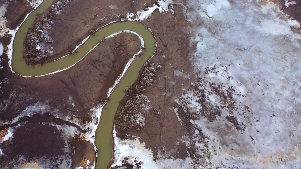 Muddy background with dirty stream. Ecology in danger. Polluted river in dried place. Disappearance of water. Aerial view.