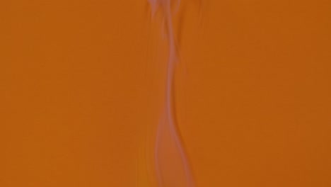 una hoja de papel naranja se quema y fuma en la pantalla azul clave de croma. el fuego quema el papel desde el medio de la hoja y lo convierte en ceniza. perfecto para hermosas transiciones de video. cerca. cámara lenta
