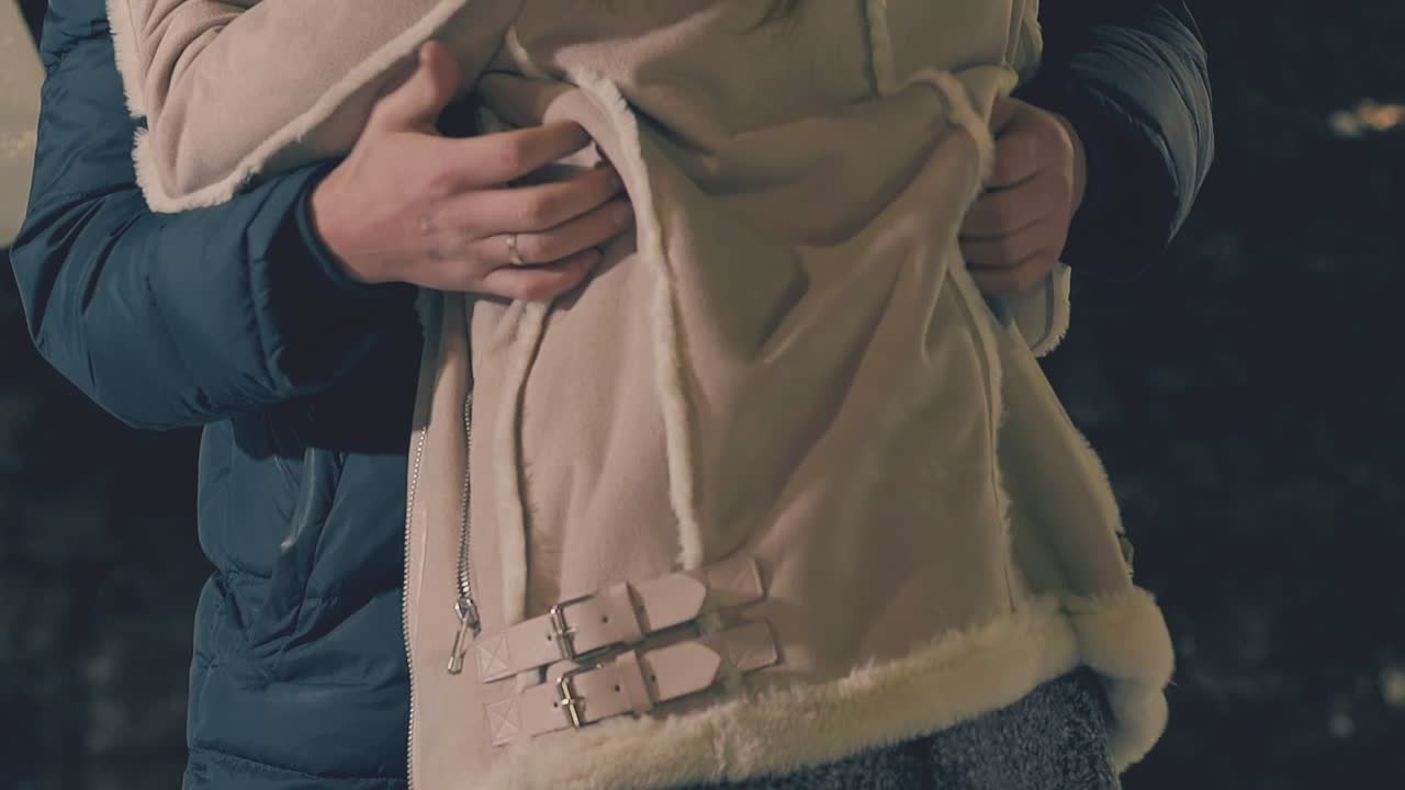 젊은 커플은 겨울 박람회 슬로우 모션에서 즐거운 시간을 보내고 포옹합니다