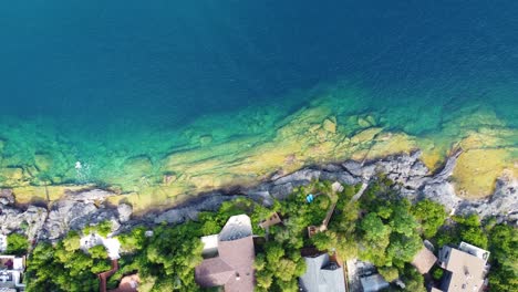 Erhöhte-Ansicht-Von-Häusern-In-Der-Nähe-Der-Georgian-Bay,-Ontario,-Kanada-Mit-Kristallklarem-Wasser