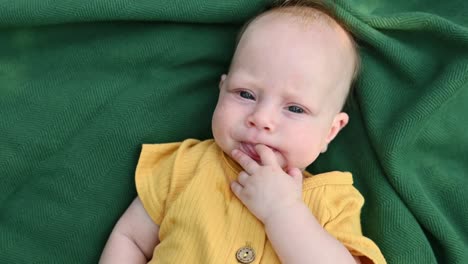 cute baby lying on blanket at park