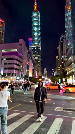 night view of taipei city with taipei 101 and person crossing the street