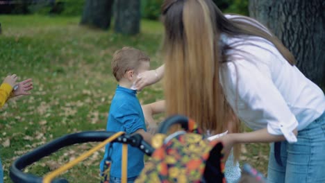 young mother and her friend wipe the faces of children