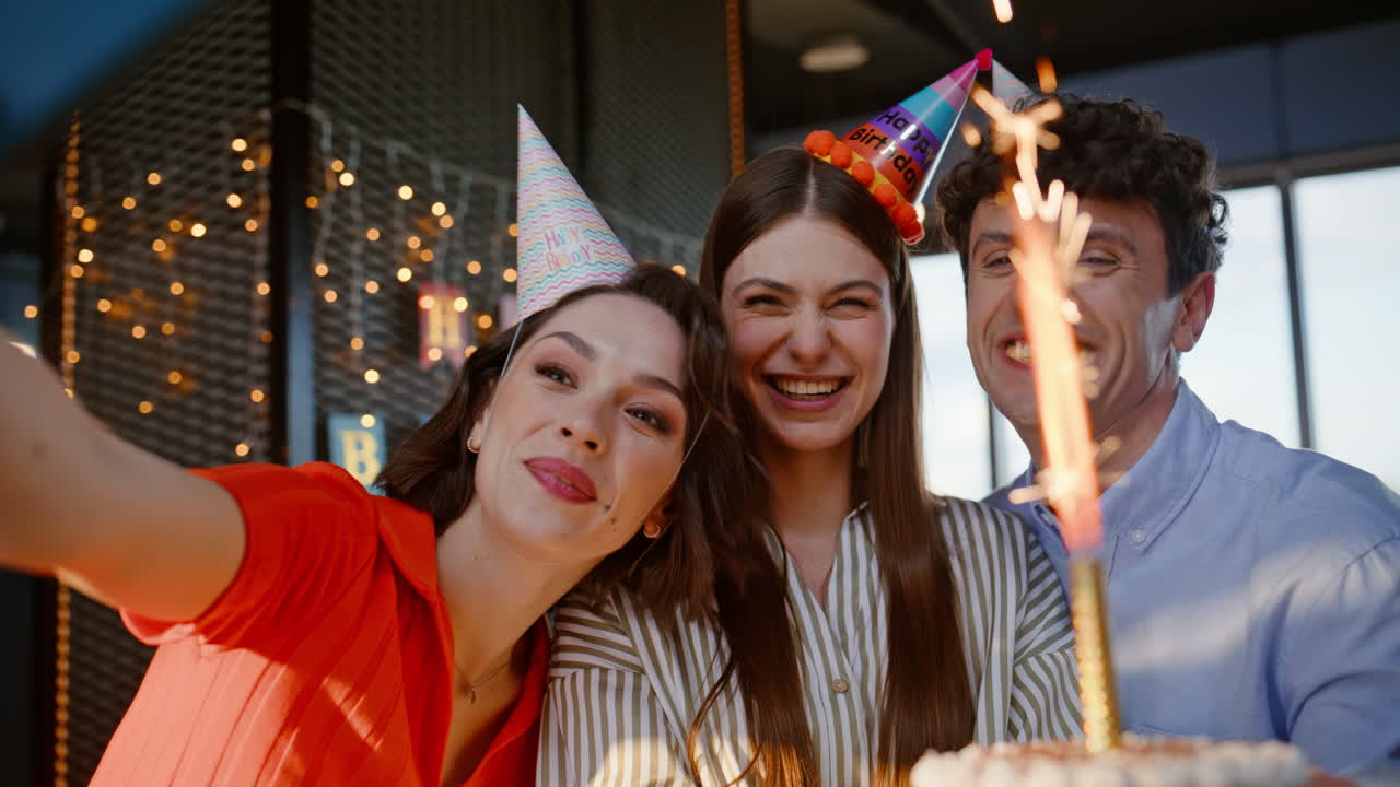 Colegas comemorando um aniversário e tirando uma foto com smartphone em close no escritório