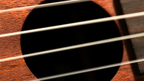 hand strumming guitar strings close up