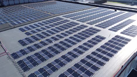 Industrial-sized-solar-panel-installation-on-rooftop-of-Asko-warehouse-in-Norway---Beautiful-approaching-aerial-with-slow-rotational-movement-and-sun-reflections-in-solar-panels