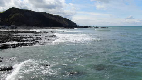 Aerial-coastal-shot-in-England-of-the-waves-in-the-sea-at-Spekes-Mill-beach-in-Devon