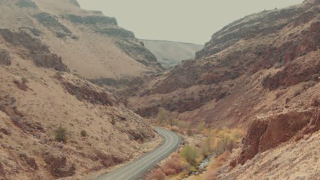 4k aerial red canyon with country road in middle drone closeup truck left