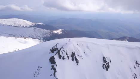 Atemberaubende-Luftaufnahme-Der-Winterlichen-Berggipfellandschaft