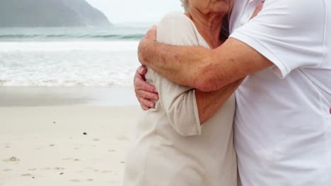 Senior-couple-embracing-each-other-on-the-beach
