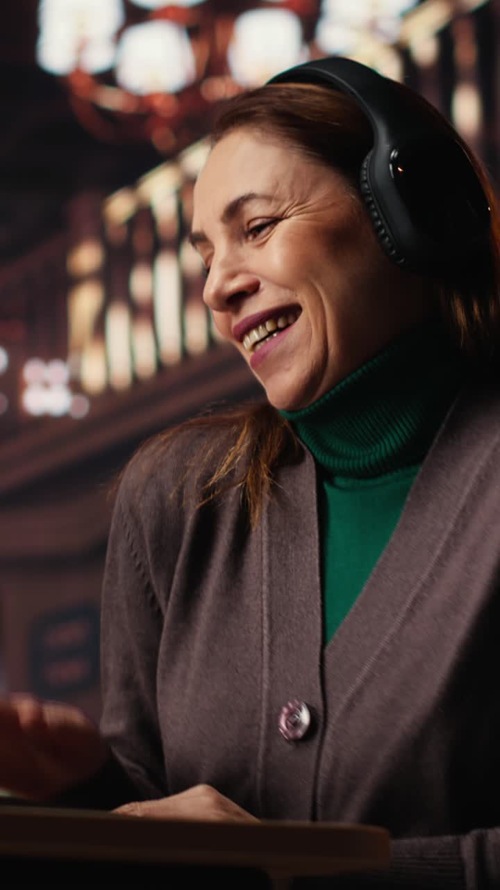 Vertical Video Mature woman listening to groovy music and singing in the library