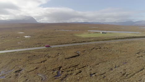 aerial tracking a red van along the a838 north coast road in northern scotland