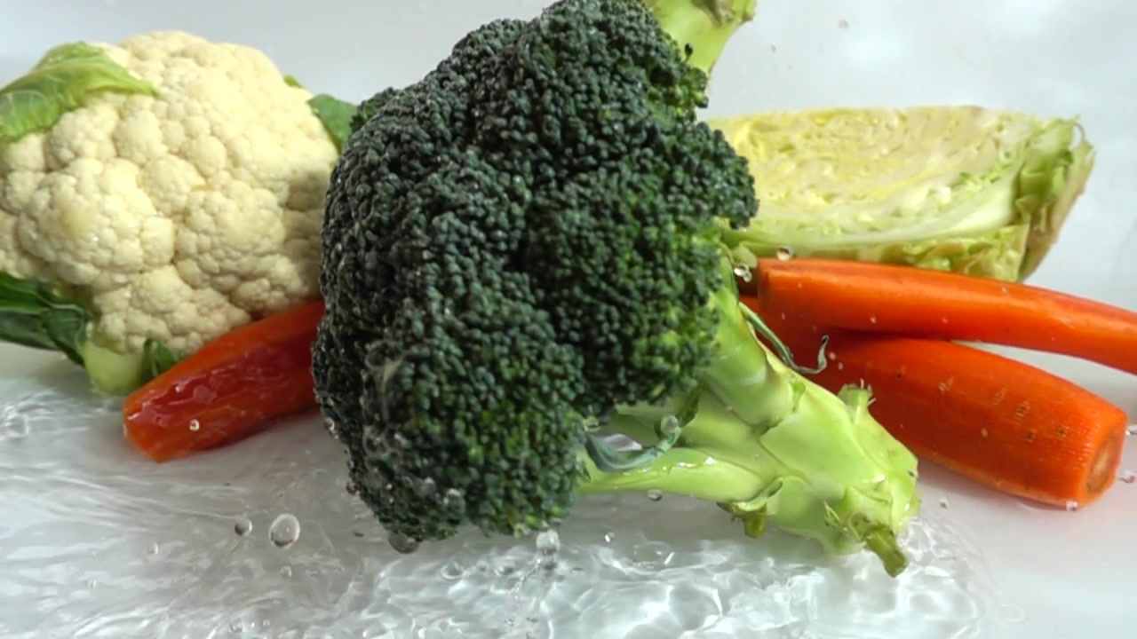 La caduta di broccoli nell'acqua. Movimento rallentato