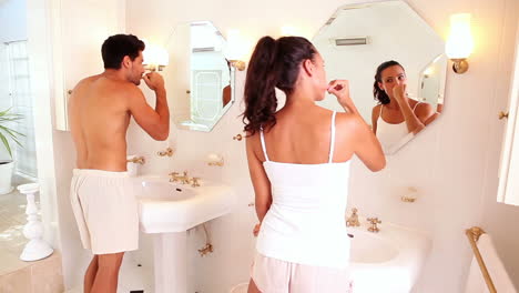 attractive couple brushing their teeth in the morning