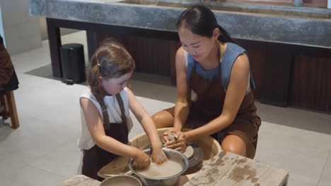 adult and child learning pottery together