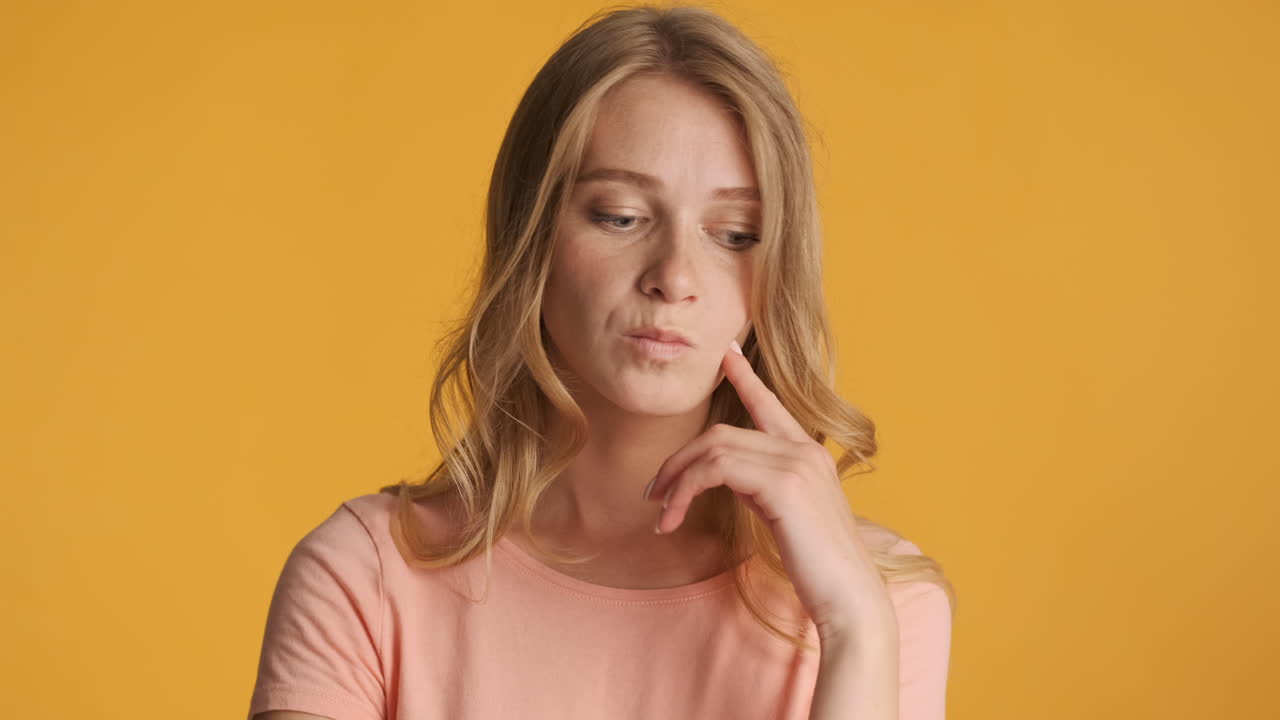 una mujer caucásica que parece dudosa ante la cámara.