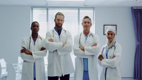 front view of multi-ethnic doctors standing together with arms crossed at hospital