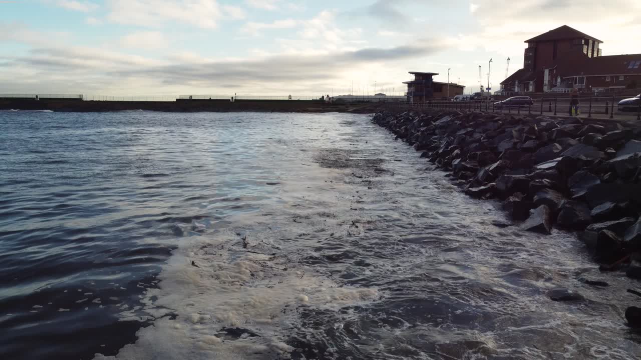 Waves crashing against rocky sea defences on an evening in roker ...
