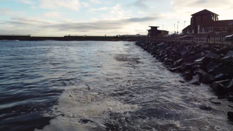 waves crashing against rocky sea defences on an evening in roker