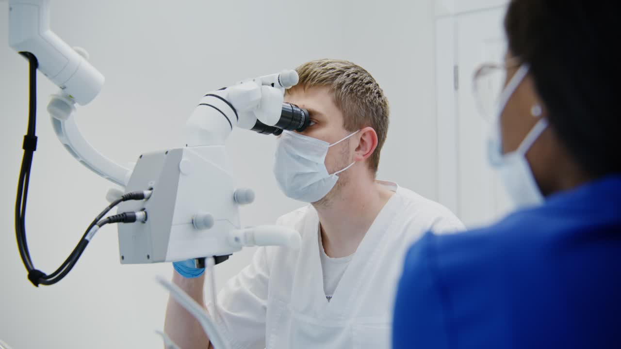 Dentist examining patient with microscope