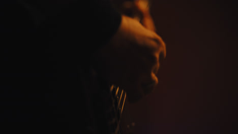 close up of fingers playing bass guitar
