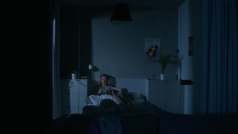 hombre y mujer relajándose en la cama por la noche