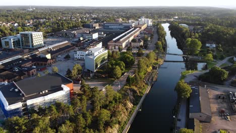 Aerial-of-Trollhättan-industrial-area-surrounded-by-green-forest-in-Sweden