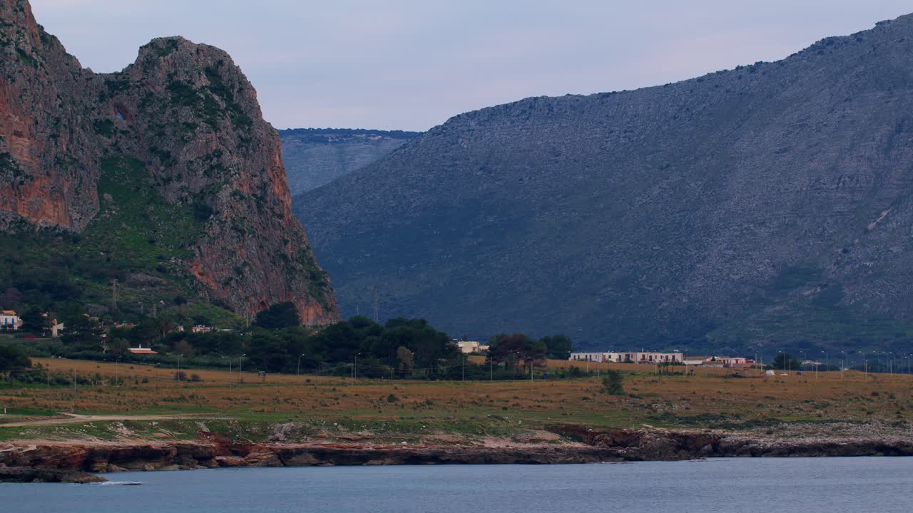 A scenic coastal view with rugged mountains in the background in San Vito Lo Capo, Sicily