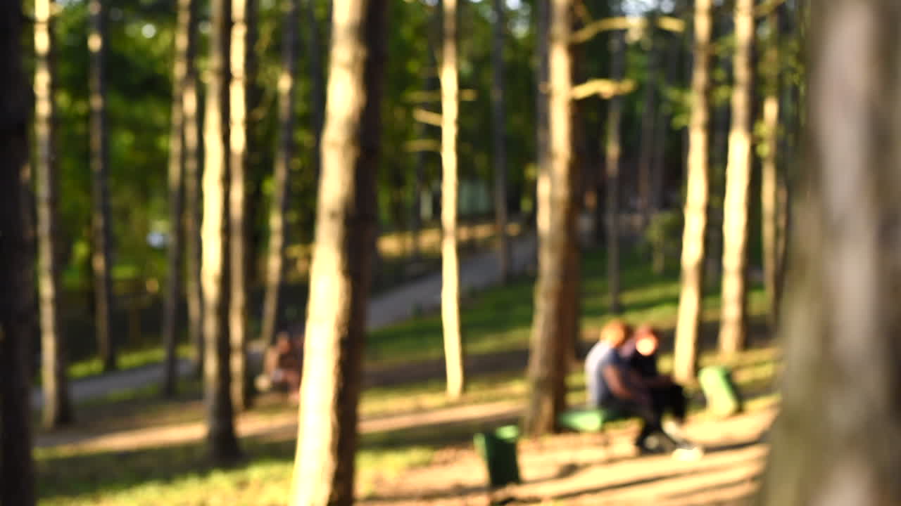 Young man in white t-shirt taking off a protective medical mask from the face and inspire air while walking in the park. Sunny day. Corona Virus idea